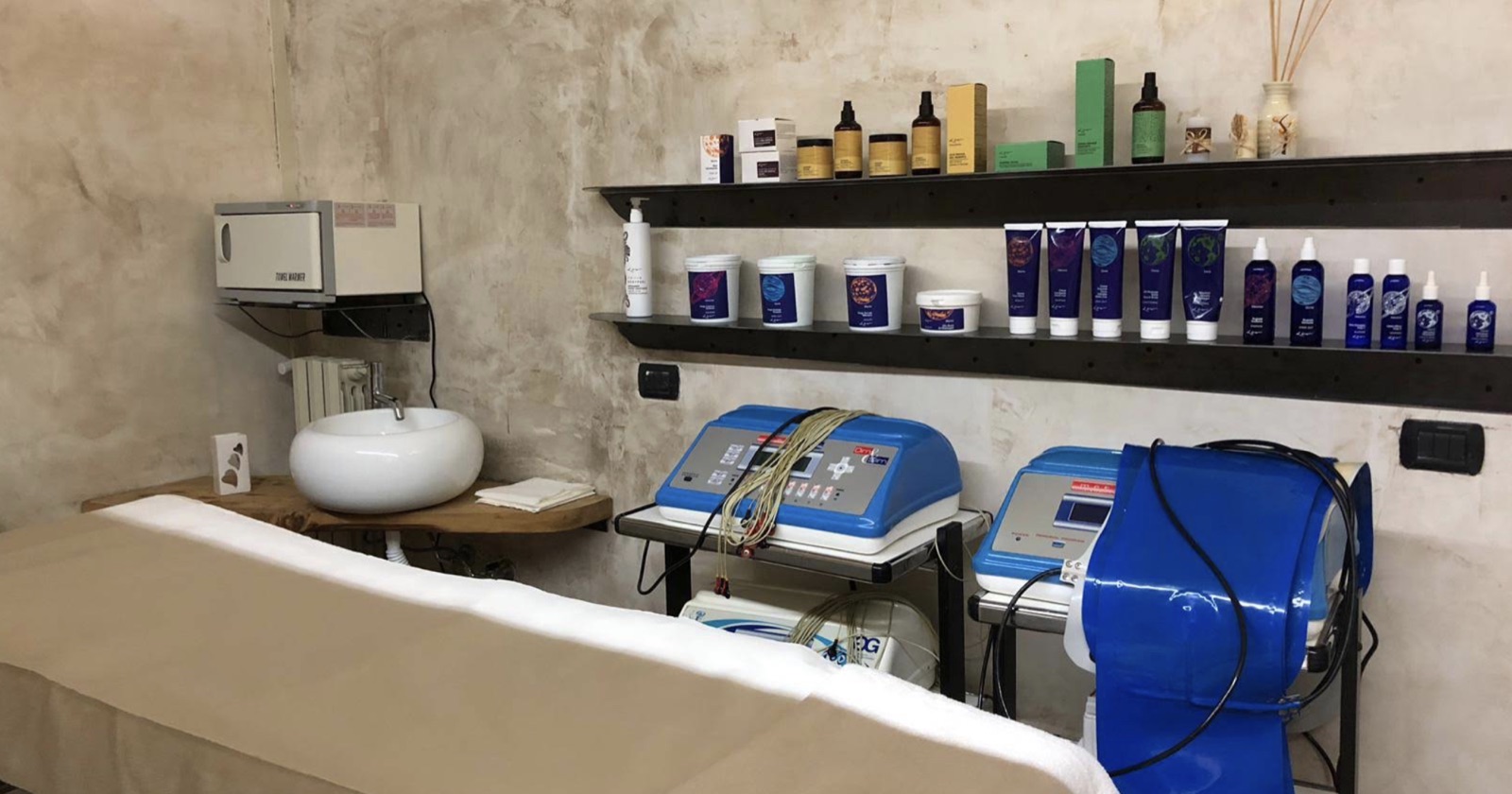 Cabina Rosemery con lettino, lavabo su mensola in legno, prodotti professionali e apparecchiature per l'estetica avanzata