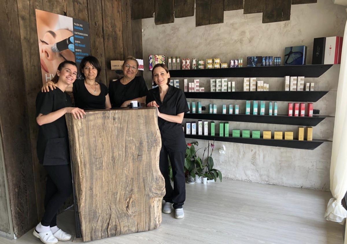 Il team Rosemery sorridente accanto al bancone in legno massello dello studio di Fizzonasco